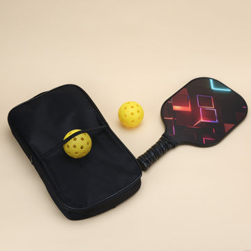 A Smash Pickleball paddle with a vibrant geometric design, a yellow pickleball, and a black mesh carrying bag laid out on a light beige background. Ideal for Smash Pickleball enthusiasts, showcasing modern paddle gear for the sport.