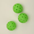 Ceiling view of three green hybrid pickleballs arranged one behind another, highlighting their vibrant color and durable design.