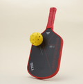 Front view of the T700 Carbon Fiber pickleball paddle in red-and-black, featuring geometric line patterns, with a yellow pickleball resting on the paddle, showcasing a dynamic and stylish design perfect for performance-driven players.
