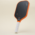 Left angle view of a performance pickleball paddle featuring a modern orange-and-black design, showcasing both contemporary style and functionality.