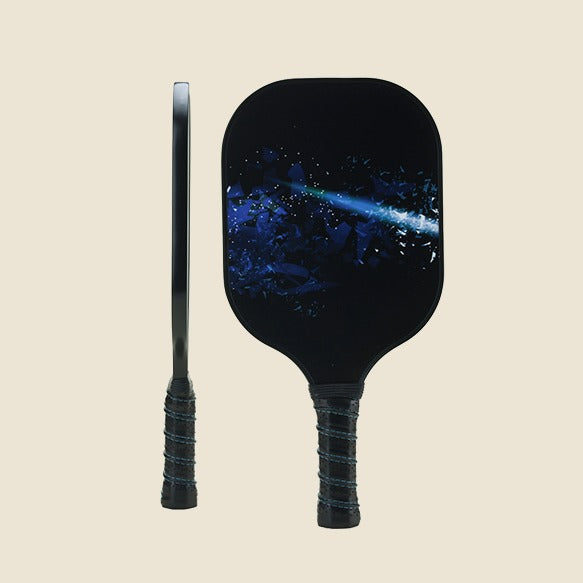  "Close-up of a pickleball paddle featuring a galaxy-themed design, showcasing both the side and front view of the paddle. The sleek and modern look is ideal for players who want a stylish and high-quality sports accessory."