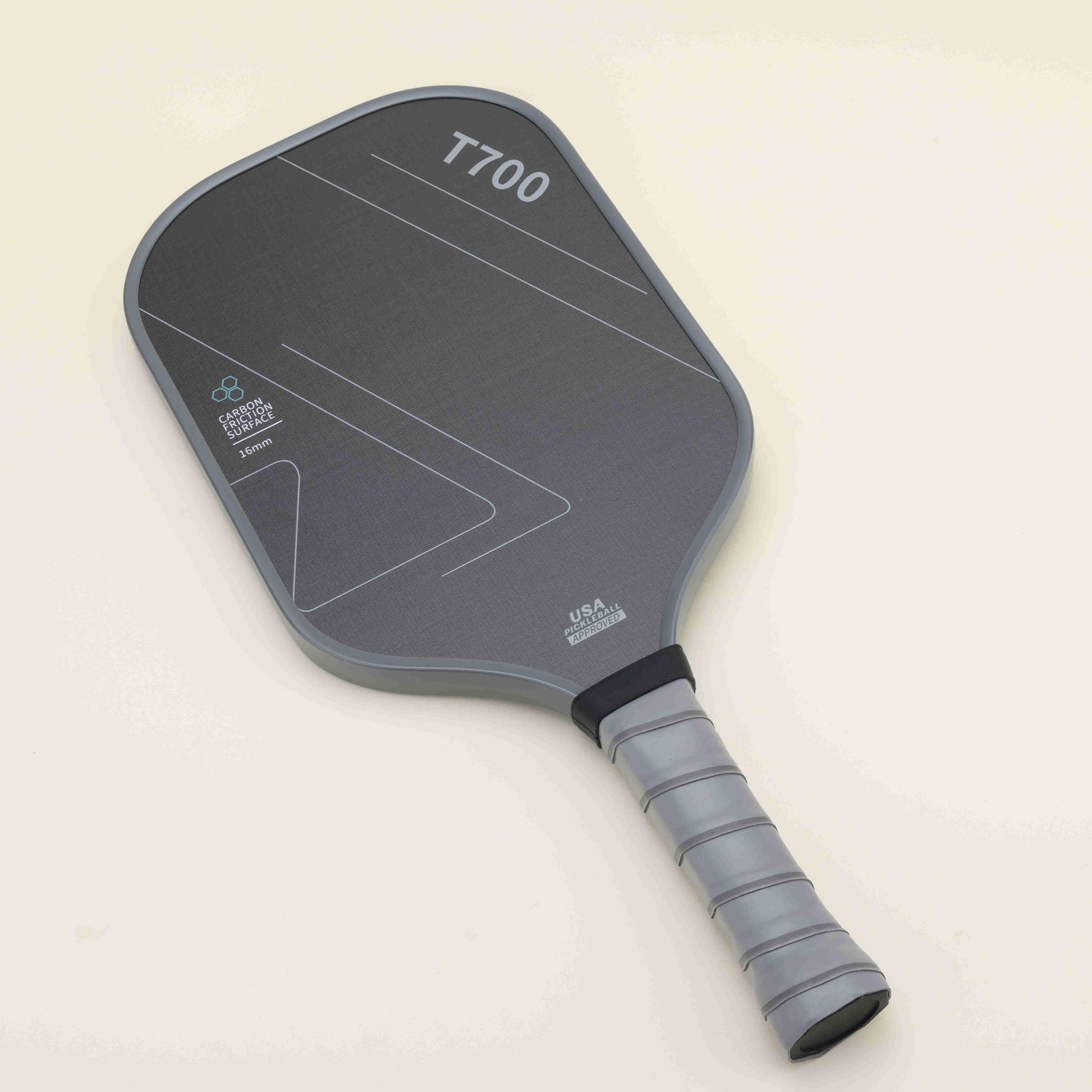 Pickleball paddle with a sleek black-gray color scheme and geometric patterns, laying flat with a yellow hybrid pickleball resting on top, showcasing a blend of modern style, power, and control.