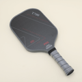 T700 Carbon Fiber pickleball paddle laid flat with a sleek black-and-gray color scheme and geometric line patterns.