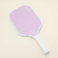 T700 pickleball paddle with an elegant and modern pink design, laying on the floor, adding a trendy touch to your game, ideal for younger players and families.