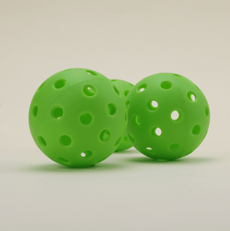 Three green hybrid pickleballs arranged one behind another, showcasing their vibrant color and durable design.