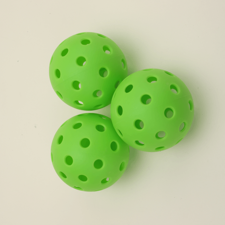 Three green hybrid pickleballs grouped together, showcasing their vibrant color and durable design.