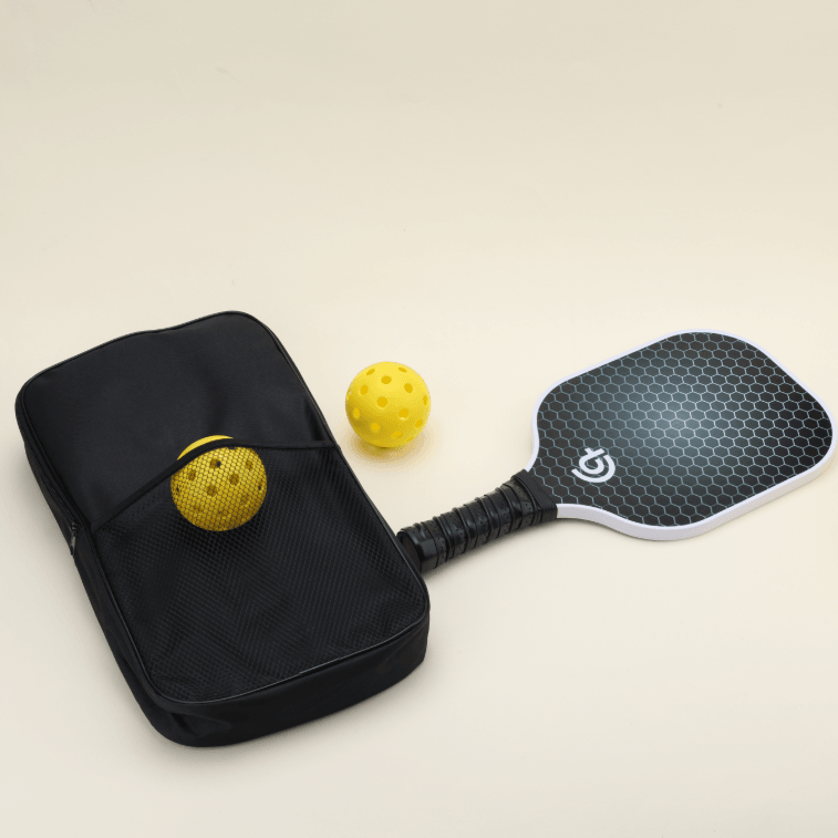 USA-approved pickleball set featuring 2 paddles in front view, with 2 pickleballs (1 yellow in the outer net pocket of the black Smash Pickleball branded carry bag and the other yellow ball placed beside the paddles), perfect for both recreational and competitive play.
